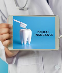 Dentist holding tablet that says “Dental Insurance”