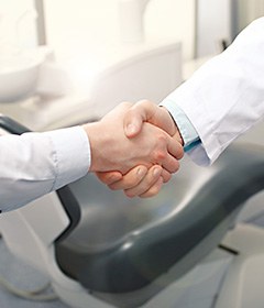 Close up of dentist and patient shaking hands