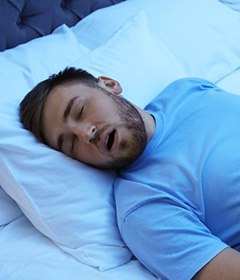 Man snoring while sleeping in bed alone