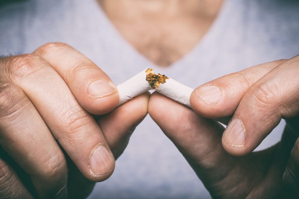 Closeup of man's fingers snapping cigarette in half